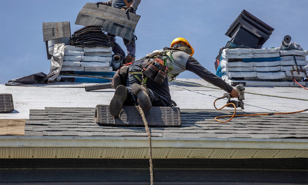 Roofer on a roof installing roofing material