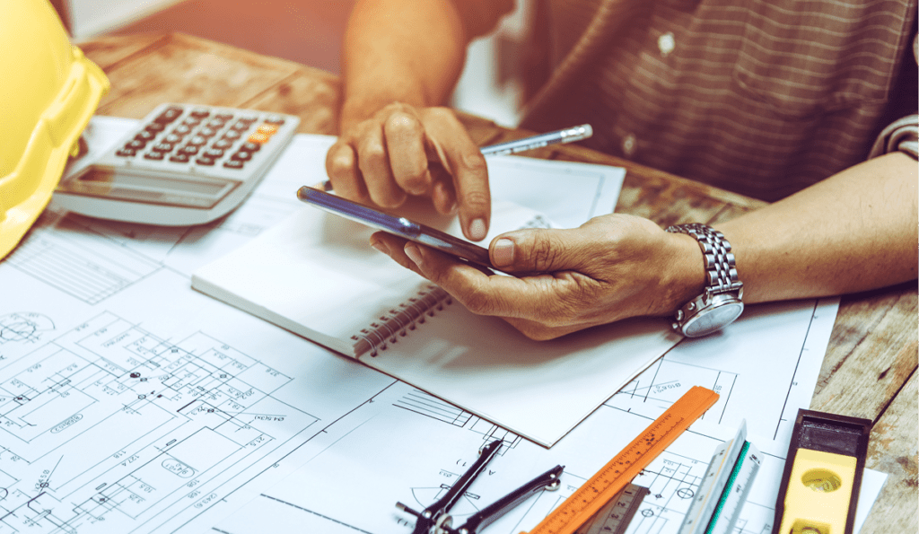 Person on desk typing on phone calculating numbers